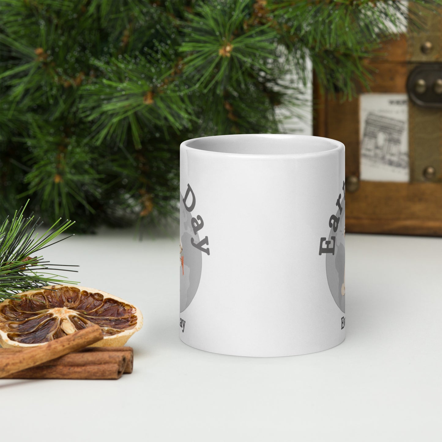 White ceramic mug with Earth Day Everyday Rabbit Ceramic Mug design next to dried orange and cinnamon sticks