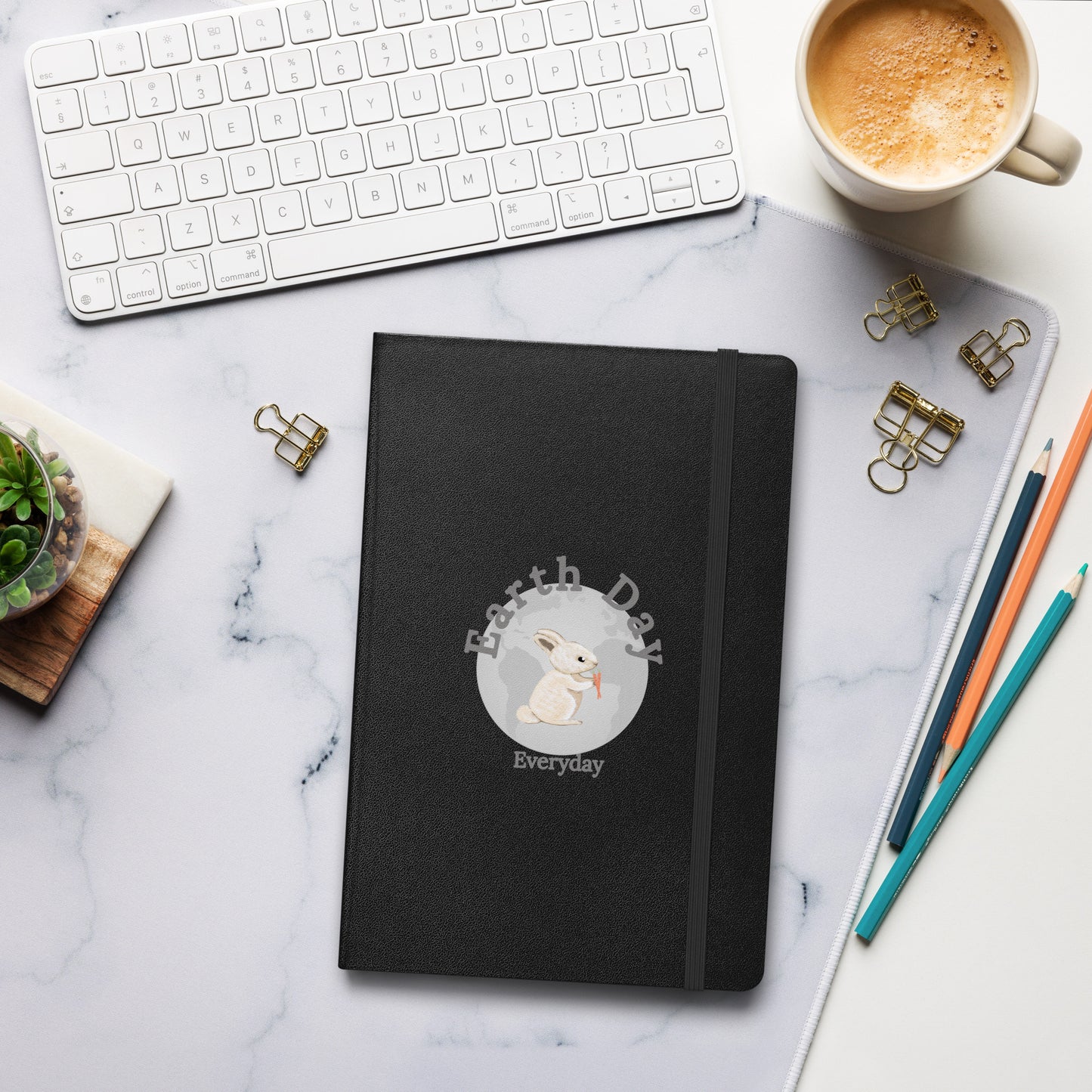Earth Day Everyday Rabbit Hardcover Bound Notebook with black cover featuring rabbit design on a marble desk