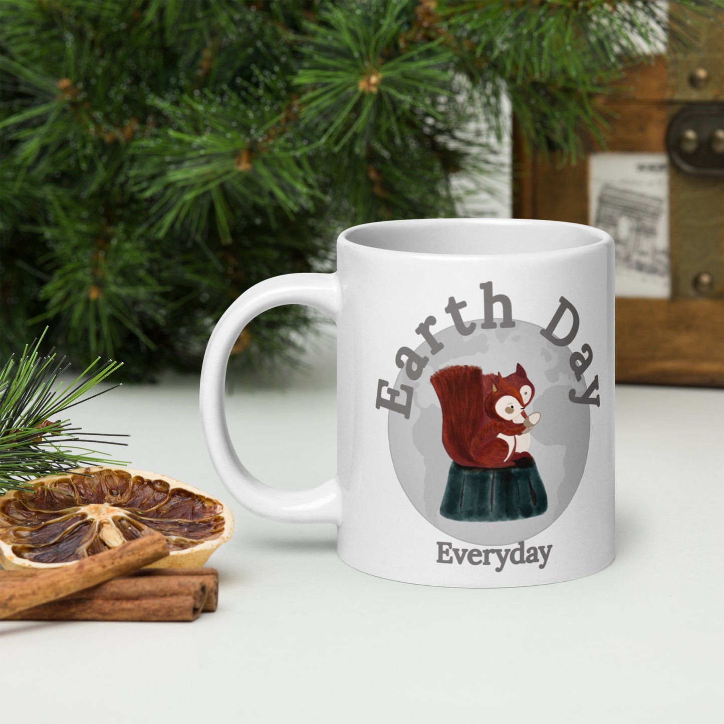 Earth Day Everyday Squirrels Ceramic Mug with squirrel graphic on white mug near pine branches and cinnamon sticks